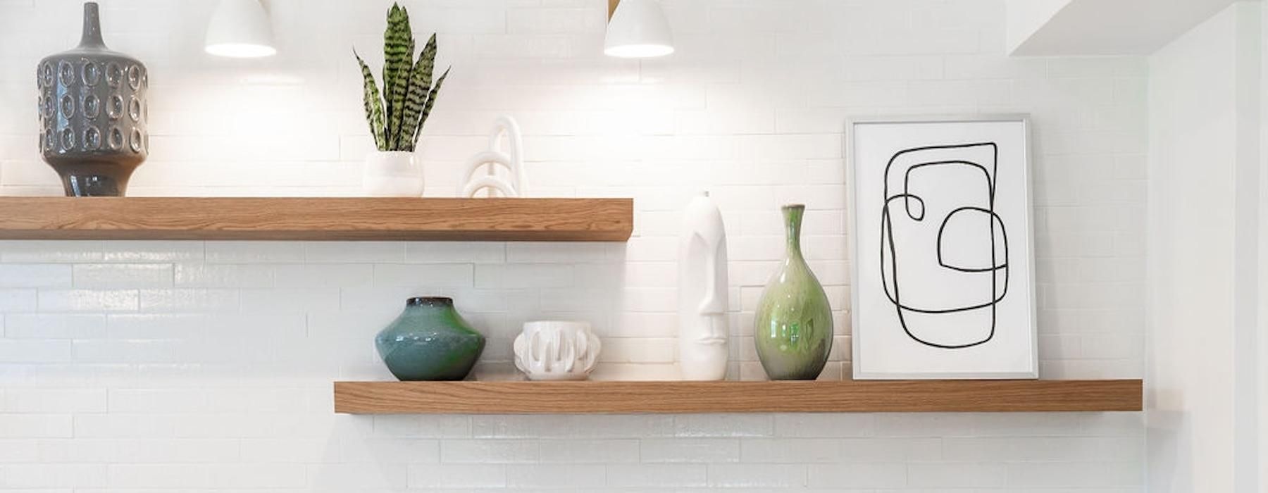 a kitchen counter with a sink and wood shelves