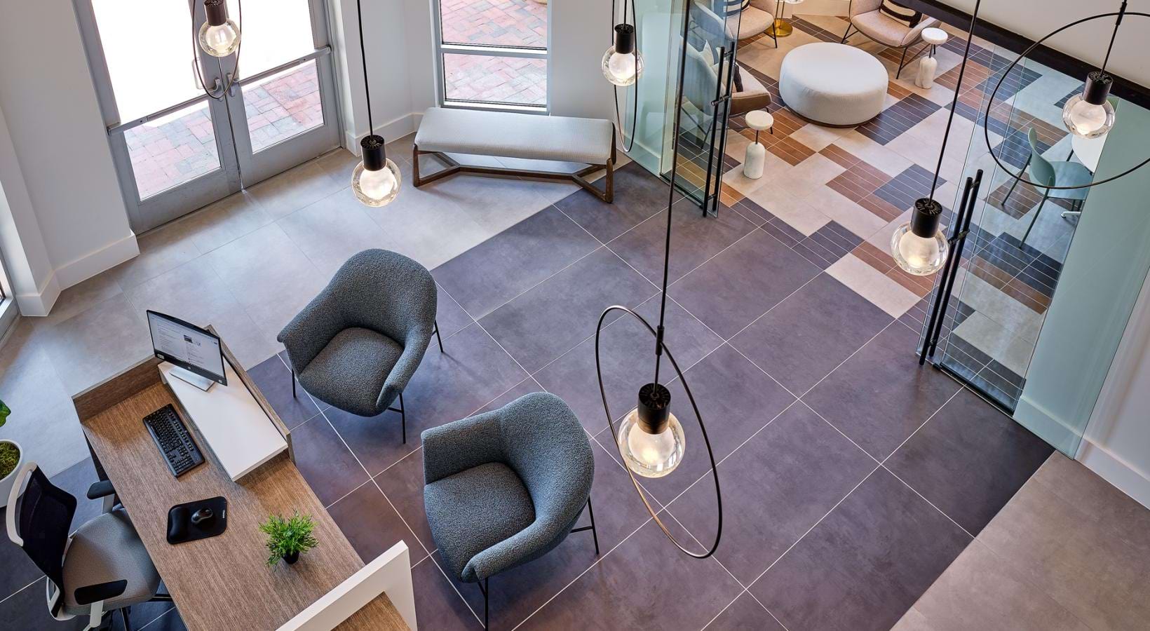 a room with pendant lighting a desk and chairs