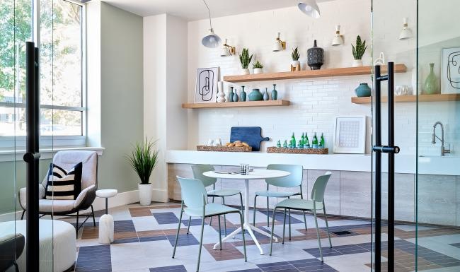 a room with a table chairs and a shelf with objects on it